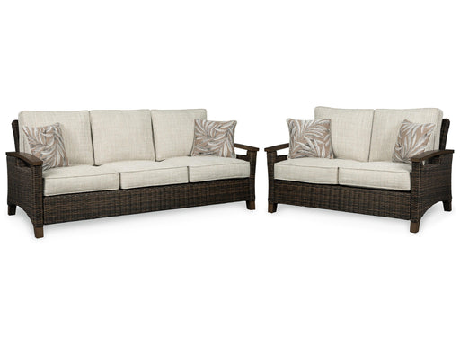 Outdoor Paradise Trail seating set by Ashley Furniture with cushioned chairs and a matching table in a backyard setting.