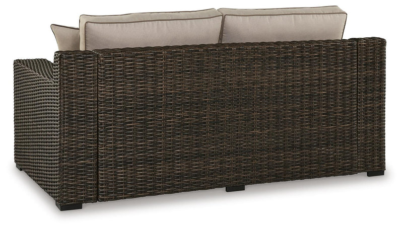 Ashley Furniture Coastline Bay outdoor loveseat with cushions, featuring a stylish patio seating design and comfortable cushion padding.
