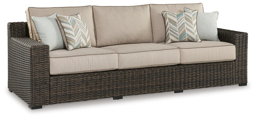 Ashley Furniture Coastline Bay outdoor sofa with beige cushions, stylish weather-resistant design perfect for patio relaxation.