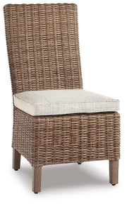Ashley Furniture Beachcroft outdoor dining set with a table and four chairs, shown from an angled perspective on a patio.