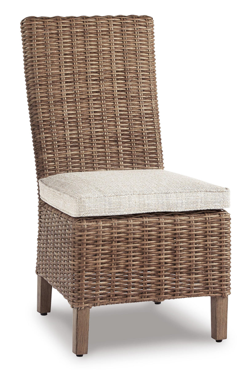 Ashley Furniture Beachcroft outdoor dining set with a round table and four chairs, set on a patio with a garden background.