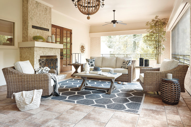 Ashley Furniture Beachcroft outdoor conversation set with cushioned seating, coffee table, and stylish wicker design for outdoor lounging.