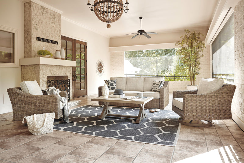 Ashley Furniture Beachcroft outdoor conversation set with cushioned chairs and a central table on a patio.