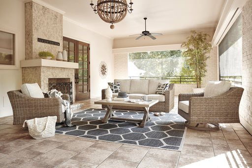 Ashley Furniture Beachcroft outdoor conversation set with cushioned chairs and a central table on a patio.