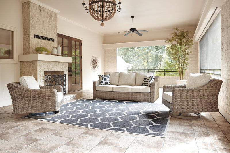 Ashley Furniture Beachcroft outdoor seating set with cushioned chairs and a matching coffee table on a patio.