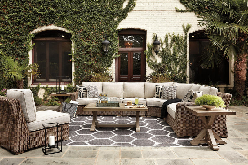 Outdoor Ashley Furniture Beachcroft outdoor seating set with cushioned chairs and a matching table on a patio.