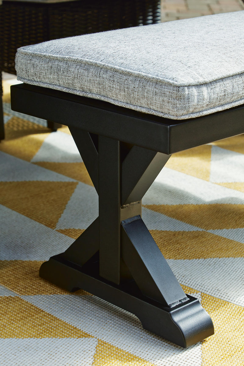 Outdoor dining bench with cushion from Ashley Furniture, featuring a sturdy wooden frame and comfortable seating for outdoor use.