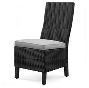 Two Ashley Furniture Beachcroft outdoor side dining chairs with cushions, shown from an angle outside.
