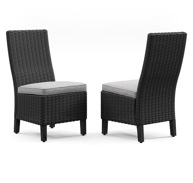 Two Ashley Furniture Beachcroft outdoor dining side chairs with cushions, shown from an angled view.