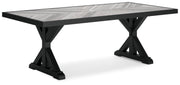 Ashley Furniture Beachcroft outdoor dining table shown from an angled view, featuring a rectangular tabletop and sturdy outdoor-ready design.