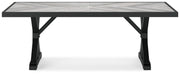 Outdoor Ashley Furniture Beachcroft outdoor dining table with wooden slats and sturdy metal frame on a patio setting.