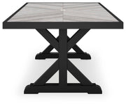 Outdoor dining table from Ashley Furniture's Beachcroft collection with a wooden tabletop and sturdy metal legs.