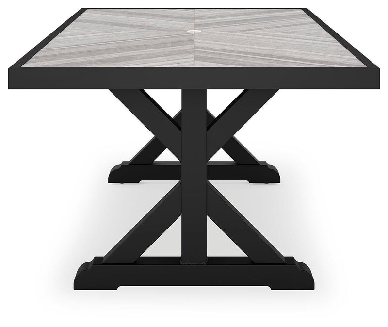 Outdoor dining table from Ashley Furniture's Beachcroft collection with a wooden tabletop and sturdy metal legs.