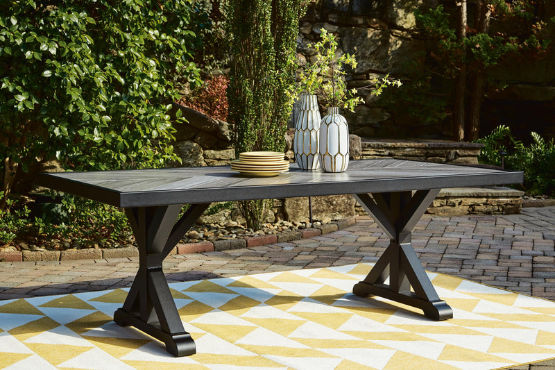 Outdoor Ashley Furniture Beachcroft outdoor dining table with slatted top and sturdy metal frame, ideal for patio or backyard dining.