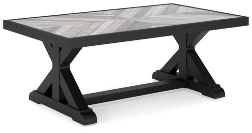 Ashley Furniture Beachcroft outdoor cocktail table with a wooden top and black metal frame, shown from an angled view.