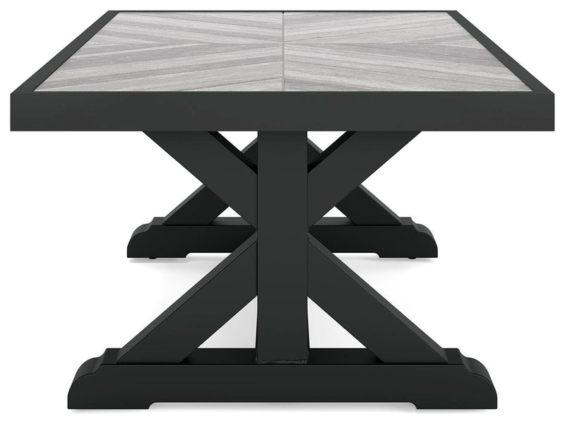 Ashley Furniture Beachcroft outdoor cocktail table with a rectangular wooden top and metal frame, designed for outdoor patio use.