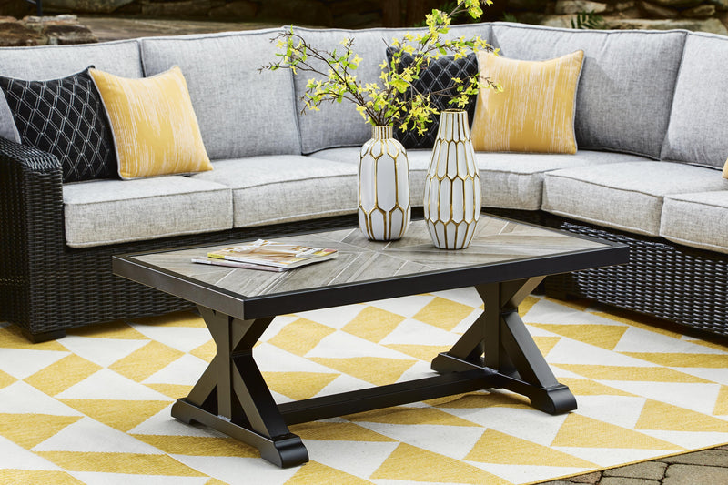 Outdoor Ashley Furniture Beachcroft cocktail table with a metal frame and glass top, ideal for patio or outdoor seating areas.