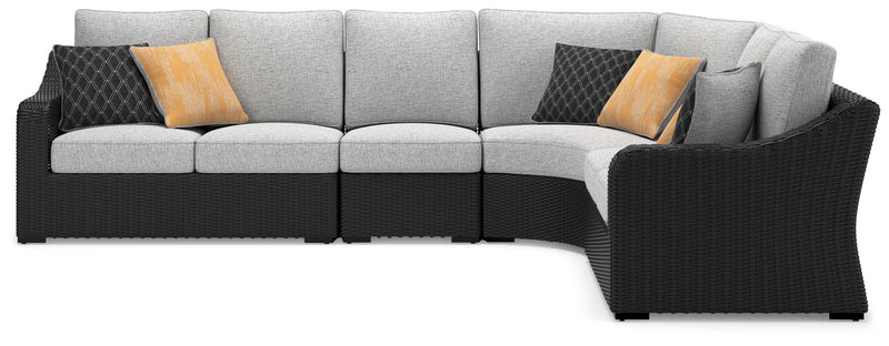 Ashley Furniture Beachcroft outdoor sectional with beige cushions and a woven rattan frame, shown from a head-on perspective.