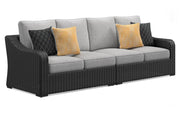 Outdoor sectional loveseat by Ashley Furniture with beige cushions, featuring a two-piece design for patio or garden seating.