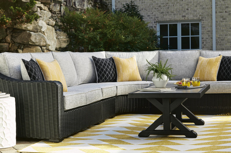 Ashley Furniture Beachcroft outdoor cocktail table with a modern design, featuring a sturdy wooden top and metal frame.