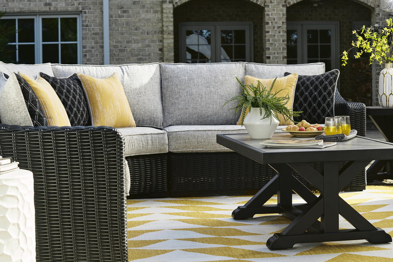 Ashley Furniture Beachcroft outdoor cocktail table with a textured surface and metal frame, perfect for patio or garden use.