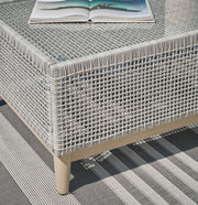 Seton Creek outdoor upholstery table set by Ashley Furniture, featuring a stylish outdoor table and matching cushioned chairs.
