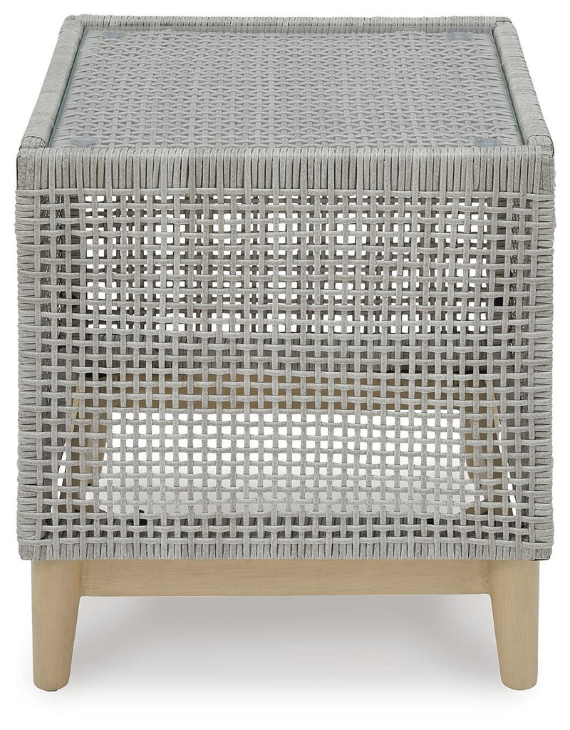 Seton Creek outdoor seating set by Ashley Furniture featuring cushioned chairs and a matching table in a cozy outdoor space.