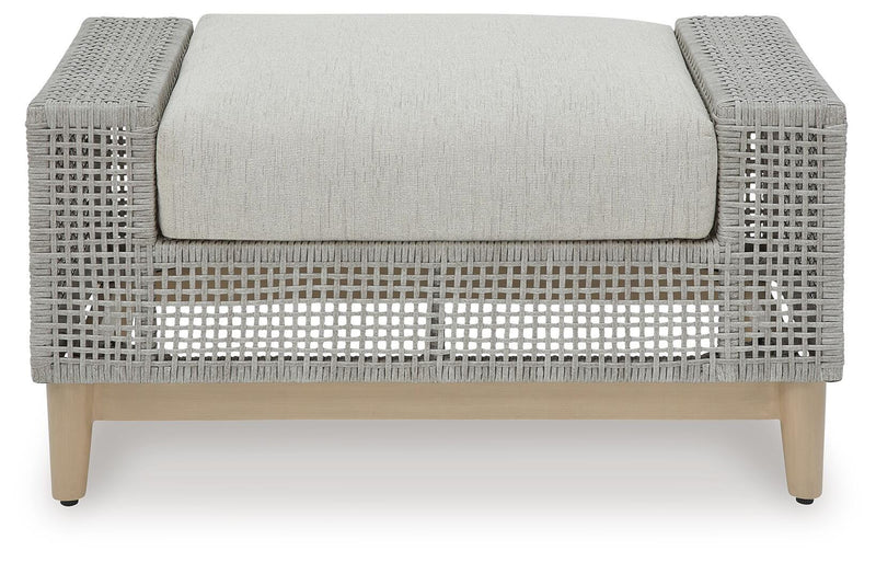 Seton Creek outdoor seating set by Ashley Furniture featuring a sofa, armchair, and coffee table in a stylish patio arrangement.