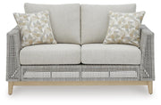 Seton Creek outdoor seating set by Ashley Furniture featuring a cozy sectional with cushions and a matching table.