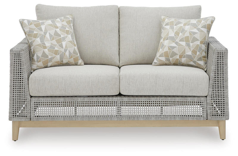 Seton Creek outdoor seating set by Ashley Furniture featuring a cozy sectional with cushions and a matching table.