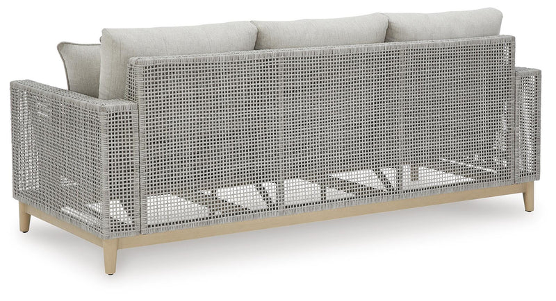Ashley Furniture Seton Creek outdoor upholstery set with table and chairs, featuring woven design and comfortable cushions.