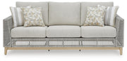 Seton Creek outdoor seating set by Ashley Furniture with cushioned chairs and a matching table in a patio setting.