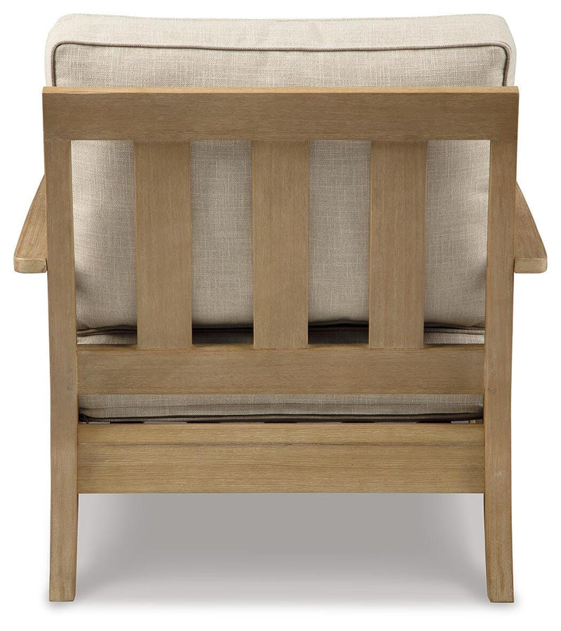 Ashley Furniture Clare View outdoor seating set with cushioned chairs and a matching table in a cozy backyard setting.
