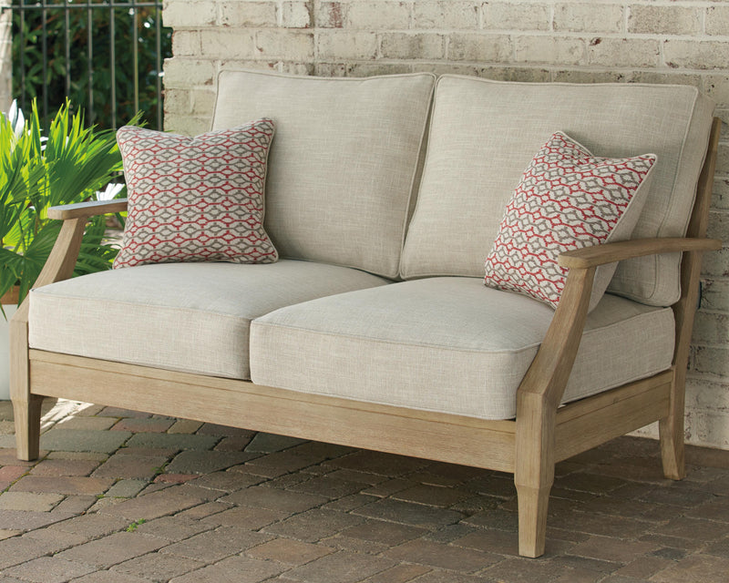 Outdoor loveseat by Ashley Furniture with cushion, featuring a cozy seating area and stylish design for outdoor relaxation.