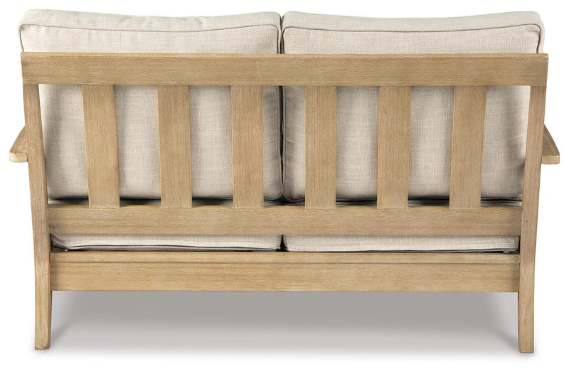 Outdoor Ashley Furniture Clare View loveseat with cushion, showing a comfortable outdoor seating area with plush cushions.