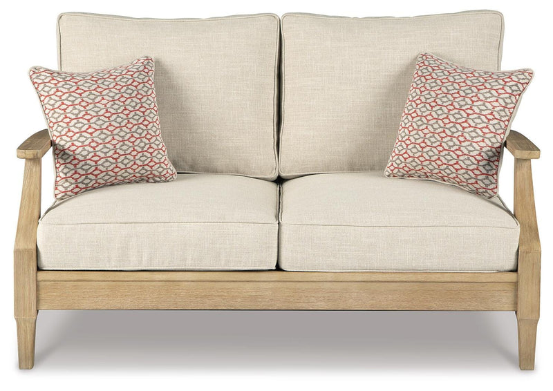 Ashley Furniture Clare View outdoor seating set with cushioned chairs and a matching table on a patio.