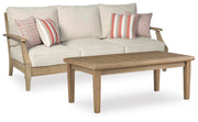 Outdoor seating set by Ashley Furniture with cushioned chairs and a matching table in a cozy patio setting.