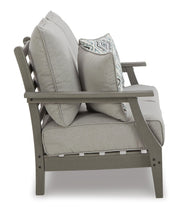Ashley Furniture Visola outdoor sofa and loveseat set with a matching table, featuring cushioned seats and stylish design.