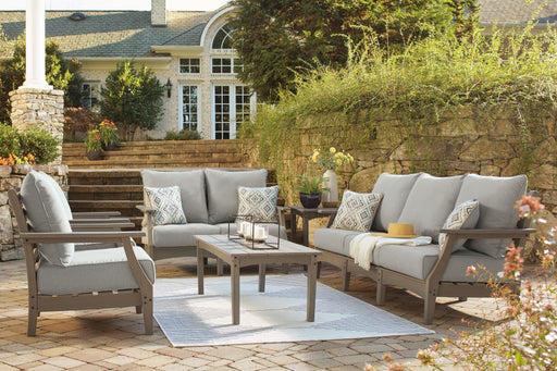 Ashley Furniture Visola outdoor sofa and loveseat set with matching table, featuring woven rattan frames and plush cushions.