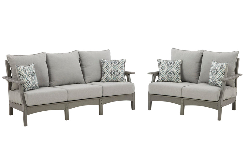 Ashley Furniture Visola outdoor seating set with cushioned chairs and table, perfect for patio relaxation.