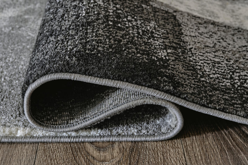 Medium Ashley Furniture Brycebourne 5'3" x 7'7" rug with intricate pattern and soft texture, shown in detailed roll image.