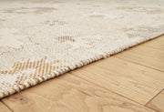 Close-up of the Ashley Furniture Calkin Rug showing intricate patterns and soft texture in neutral tones.