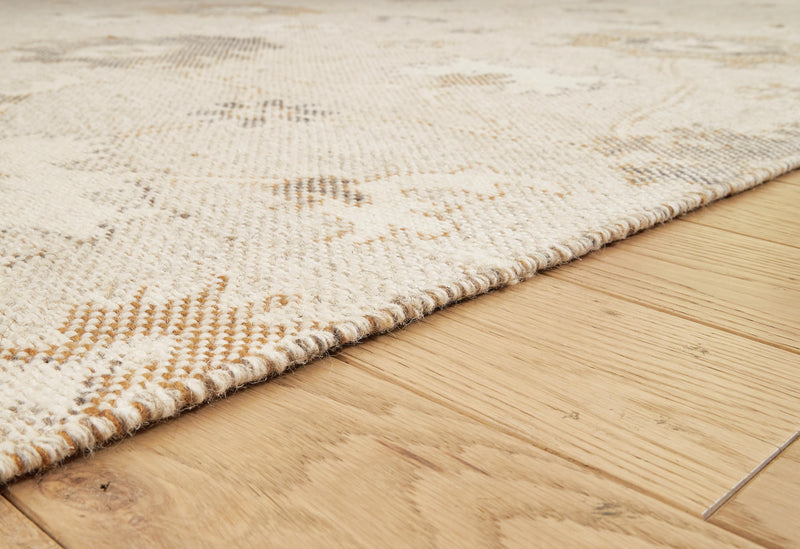 Close-up of the Ashley Furniture Calkin Rug showing intricate patterns and soft texture in neutral tones.