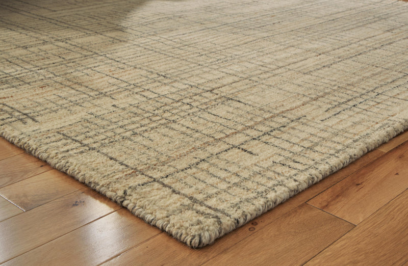 Close-up of Ashley Furniture Janston Rug showcasing detailed woven pattern and soft texture in neutral tones.