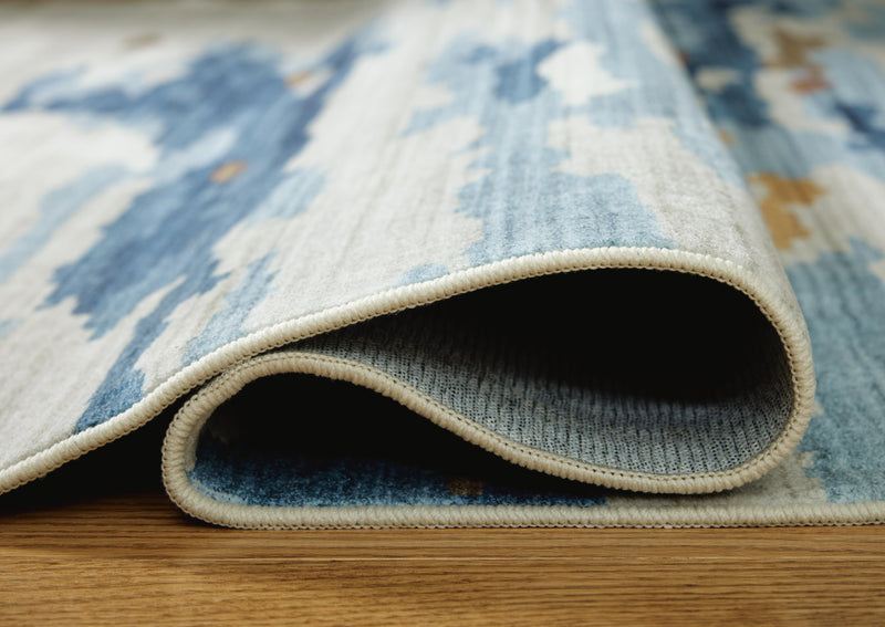 Medium washable rug from Ashley Furniture, detailed view showing soft, durable fabric and neutral color for modern home decor.