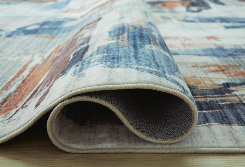 Close-up of Ashley Furniture Hessland Washable Rug, showing detailed pattern and soft texture in a neutral color.