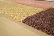 Close-up of the Ashley Furniture Gailmore Rug featuring intricate patterns and soft, woven fabric in warm earth tones.