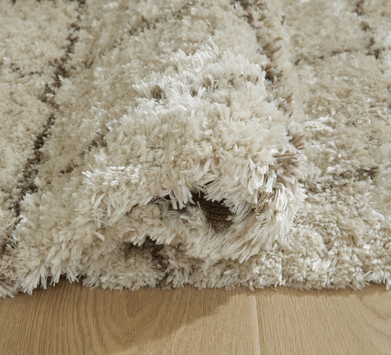 Close-up of Ashley Furniture Wrenlow Rug showcasing detailed woven pattern and rich textures in neutral tones.