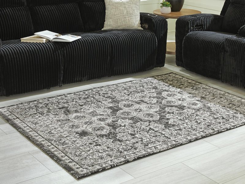 Medium Ashley Furniture Glennisman rug with intricate pattern in neutral tones displayed in a home setting.