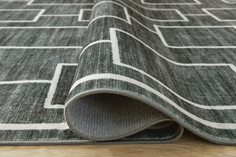 Large Ashley Furniture Elderland washable area rug, 7'6" x 9'6" with detailed woven pattern in neutral tones.